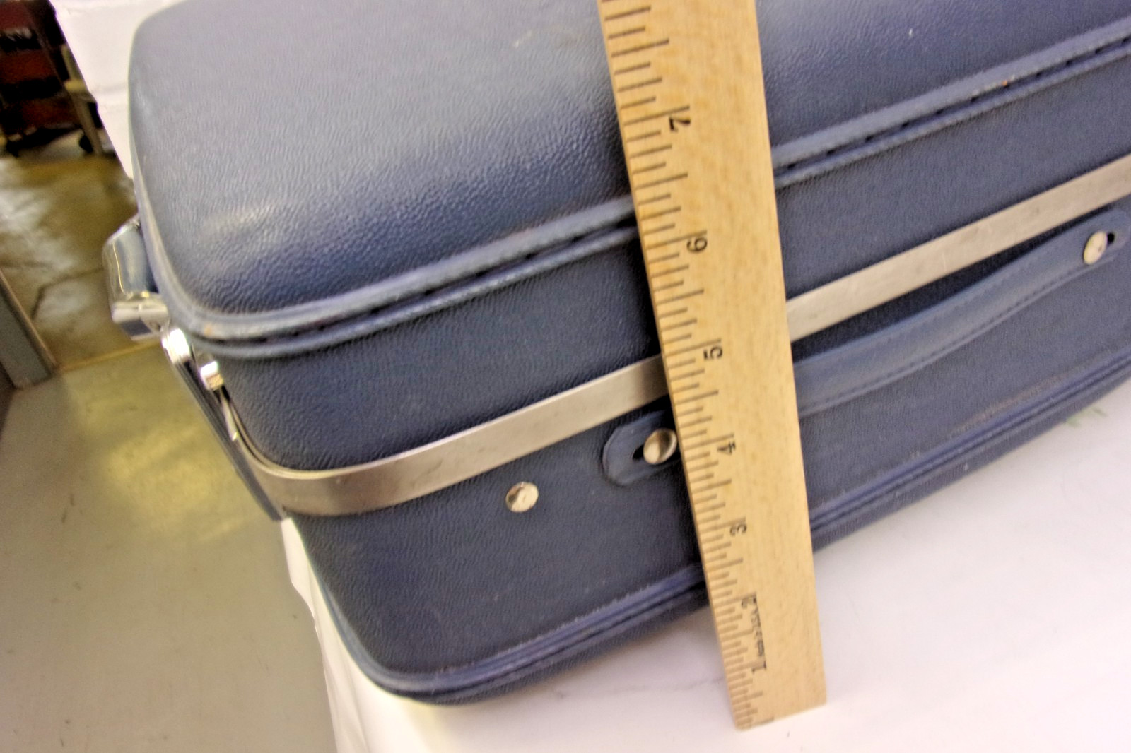 Vintage American Tourister hard-shell blue suitcase with chrome accents.