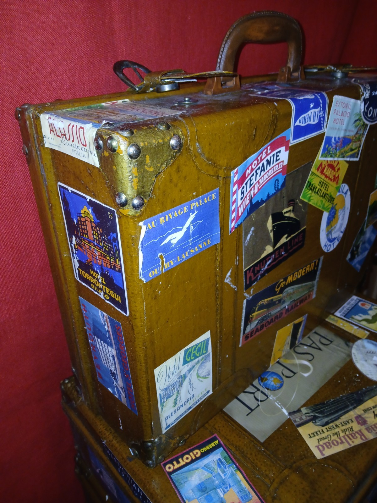 Set Of 4 Vintage Traveling Suitcases By “Keith ” with brown wooden trunk.