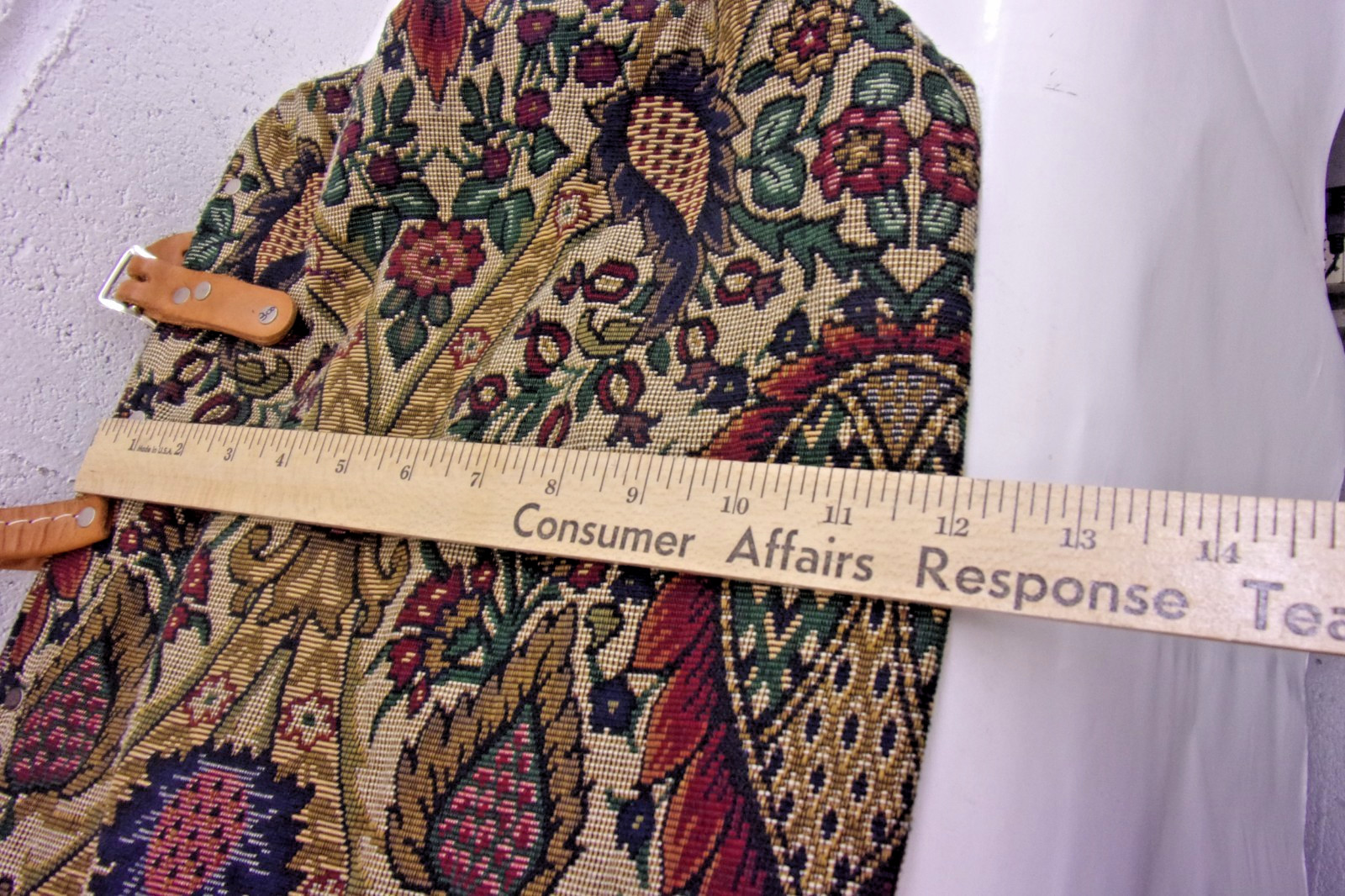 Victorian-era tapestry travel bag with leather handles and metal frame