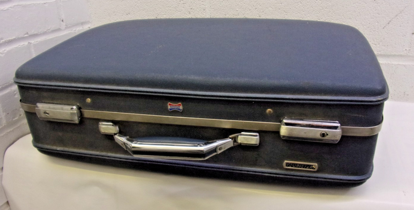 Vintage American Tourister hard-shell blue suitcase with chrome accents.