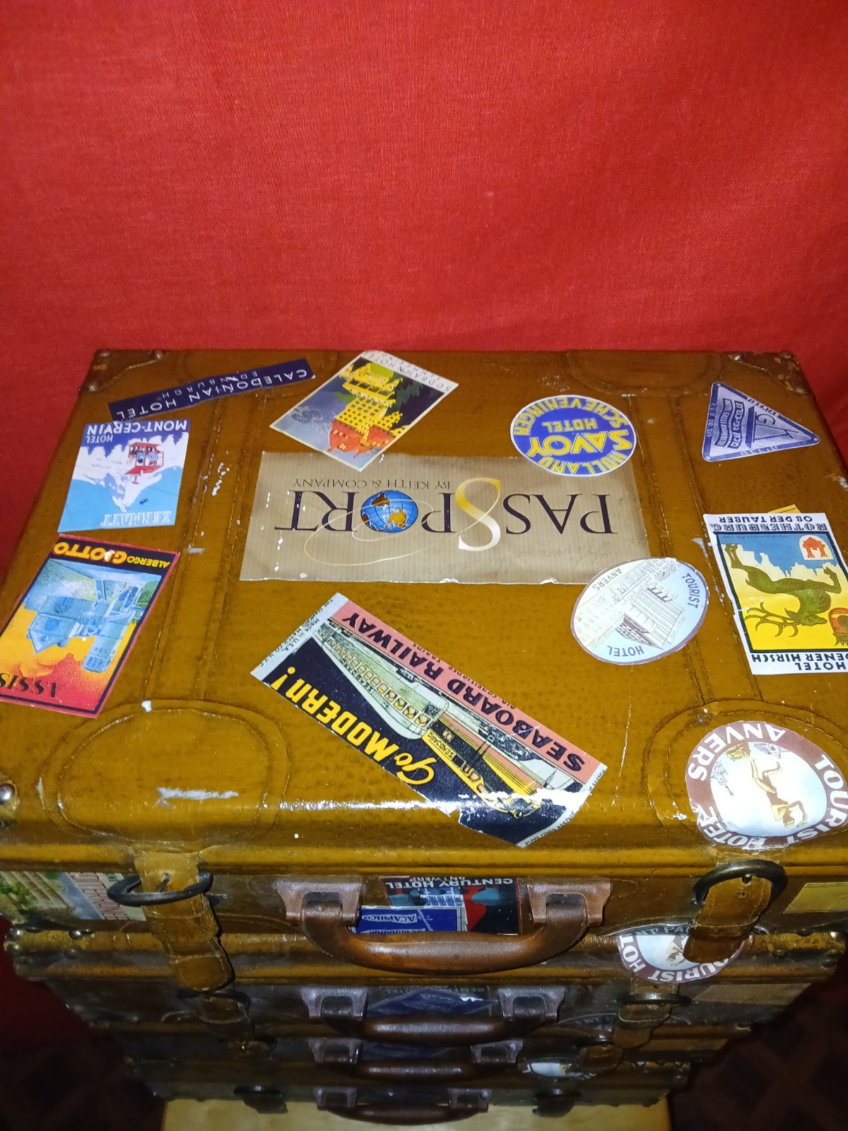 Set Of 4 Vintage Traveling Suitcases By “Keith ” with brown wooden trunk.